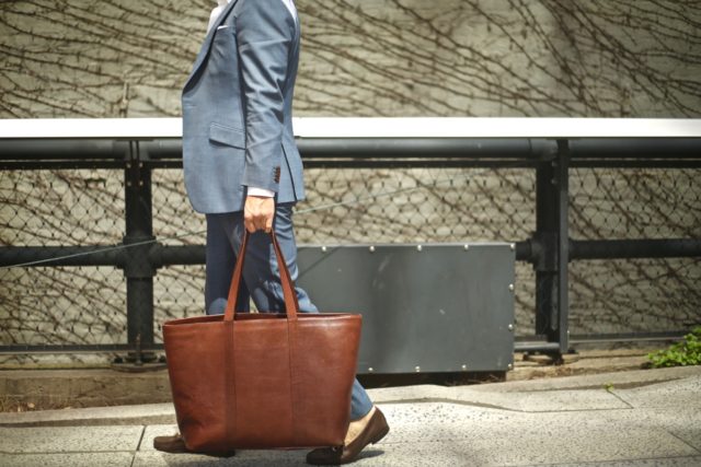 black lapel suit with jay butler brown leather tote bag